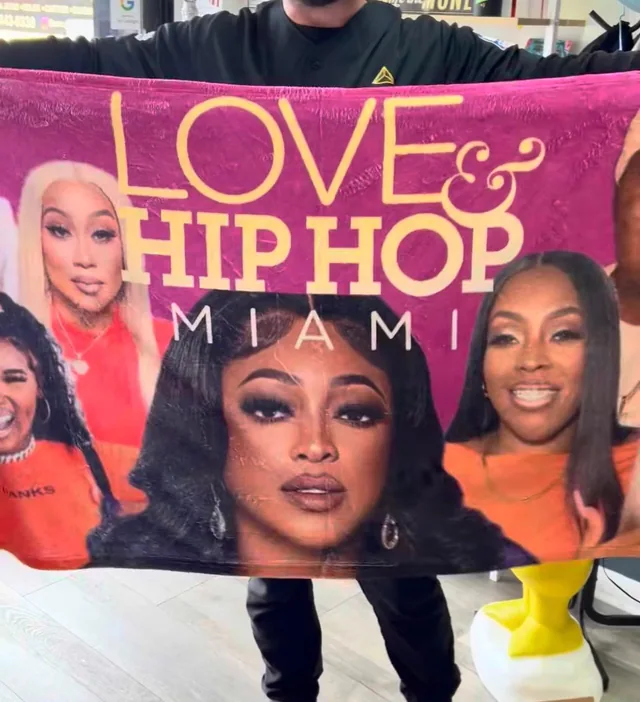 Person displaying a large pink Love and Hip Hop Miami print