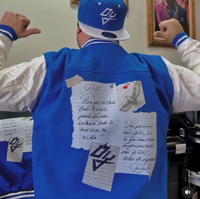Back of a blue-and-white varsity jacket with custom printed lettering and graphics