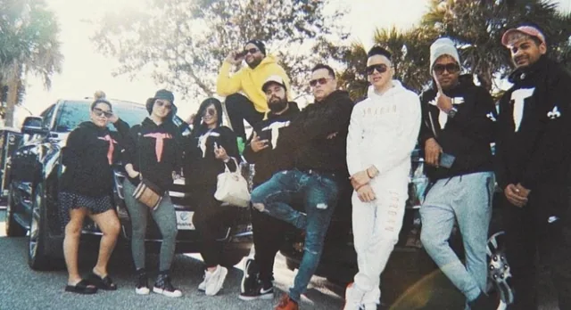 Group outdoors wearing coordinated graphic hoodies in black, white, and yellow