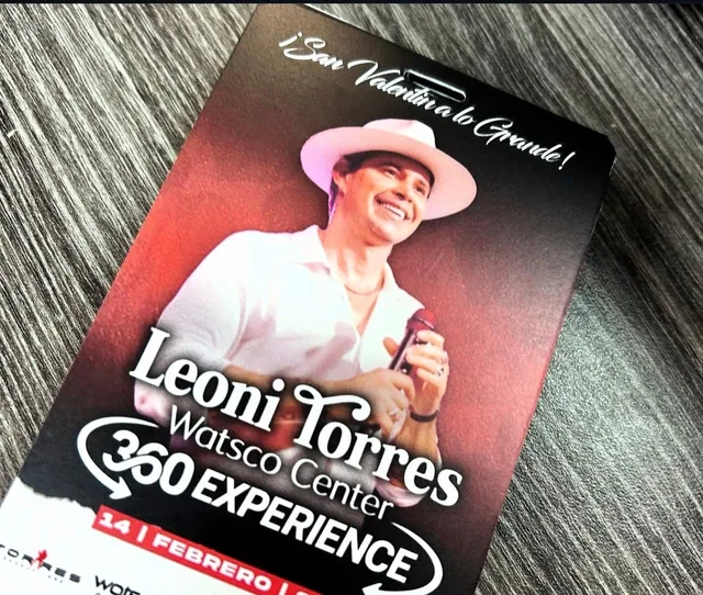 Printed Leoni Torres concert promotional piece on a wood surface