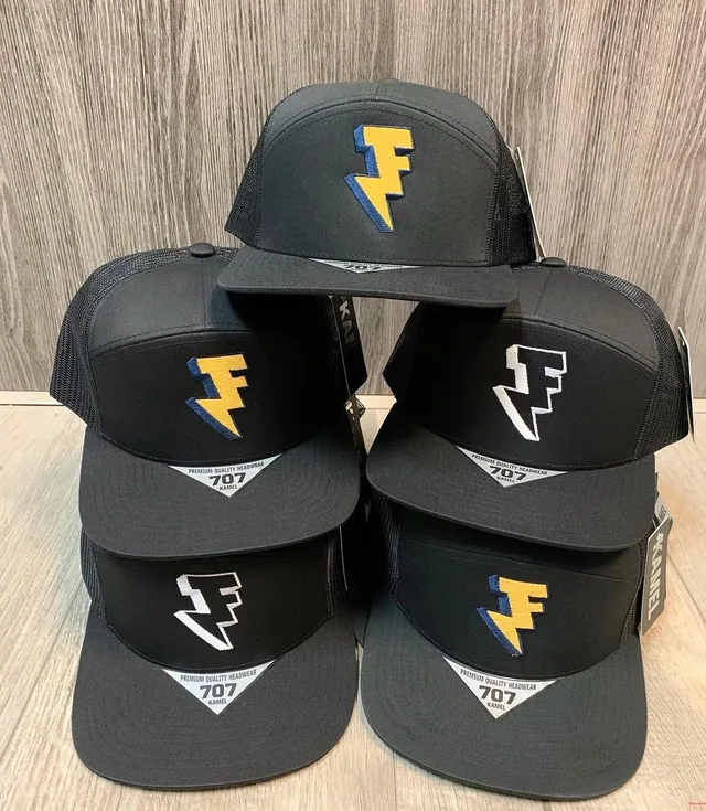 Stacked dark caps with gold and white embroidered symbols