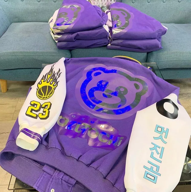 Purple graphic apparel with gold and black accents arranged in the shop