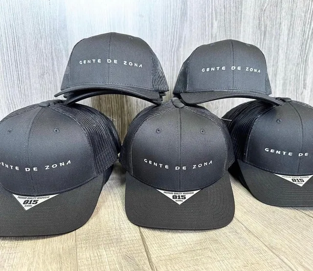 Dark caps with small white embroidered lettering arranged on a tabletop